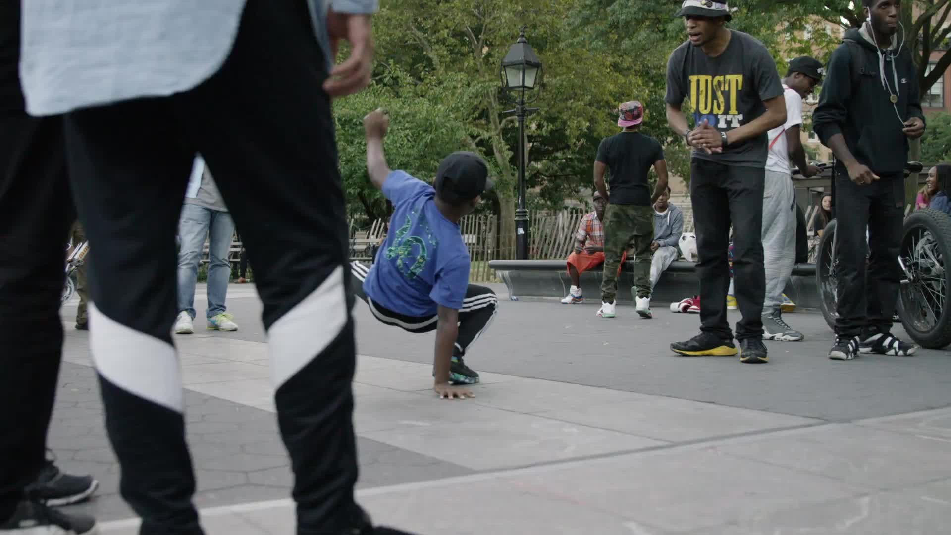 B Boy doing head-spin in summer - breakdancing in Washington Square Park in NYC