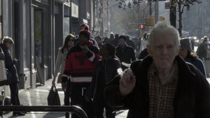 elderly man walking in midtown - cold winter day - old man carrying shopping bag over shoulder slow motion