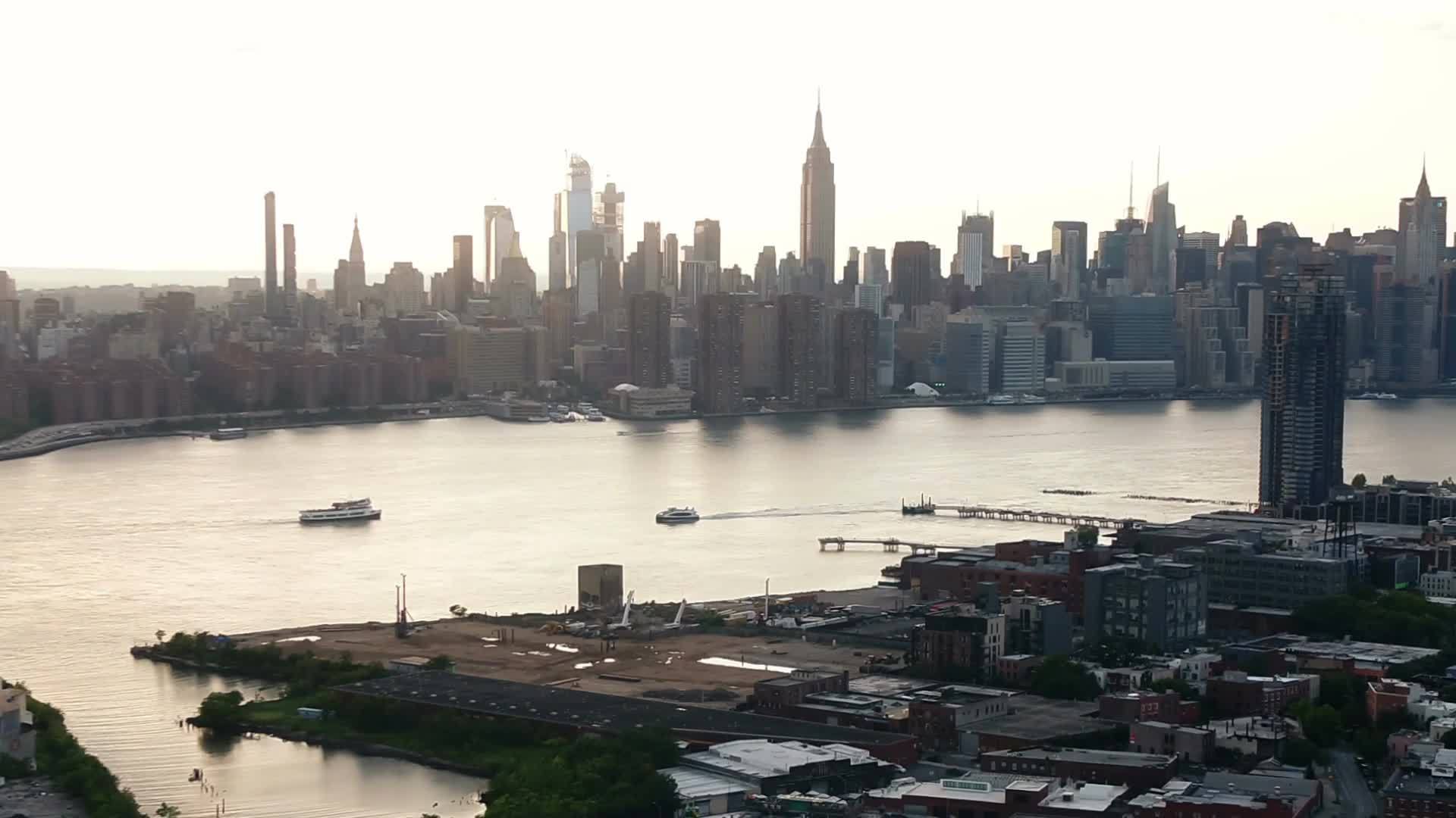 Brooklyn aerial moving toward Manhattan skyline at sunset NYC