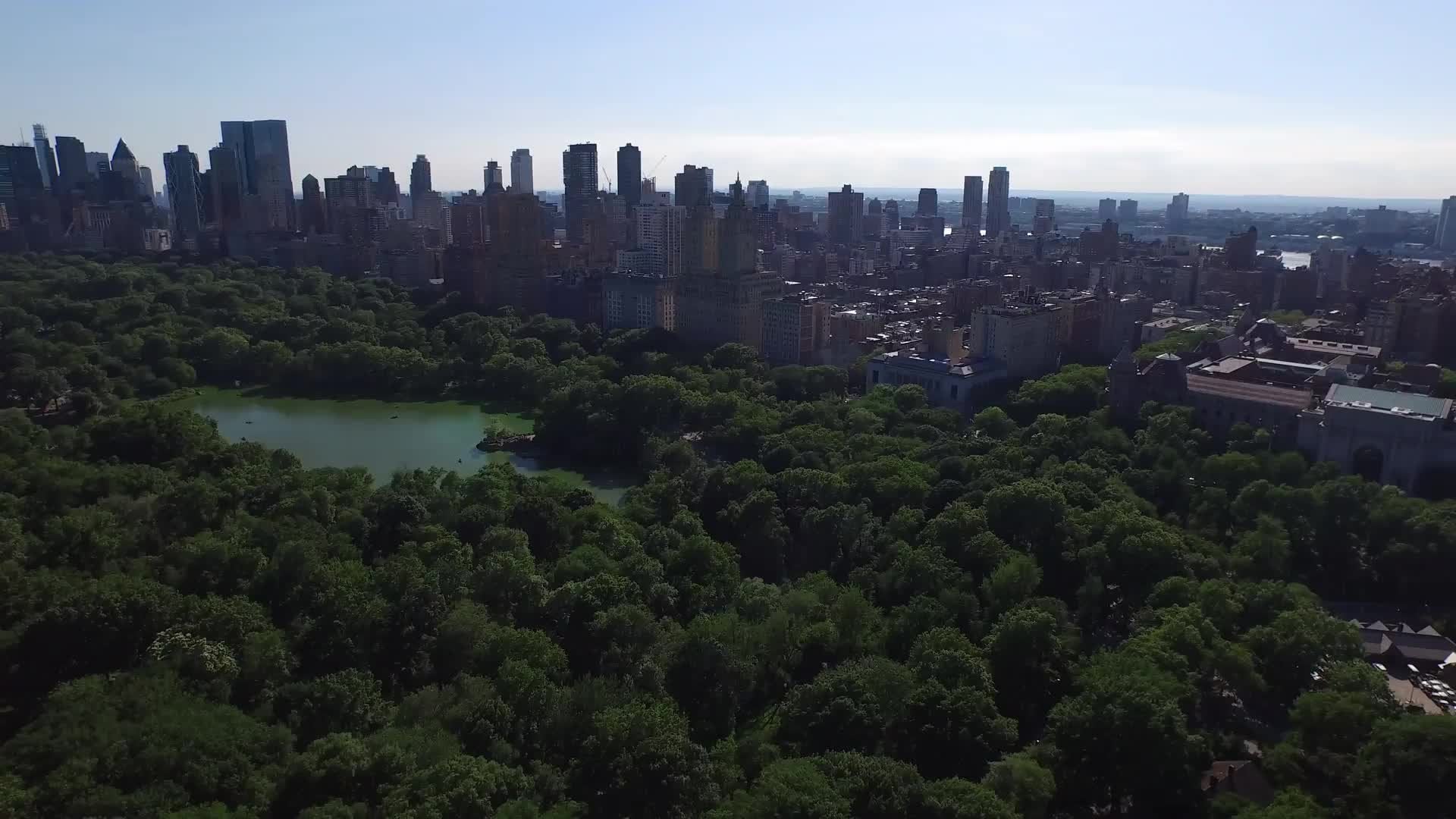 Central Park over trees and pond with skyscrapers in distance Manhattan NYC