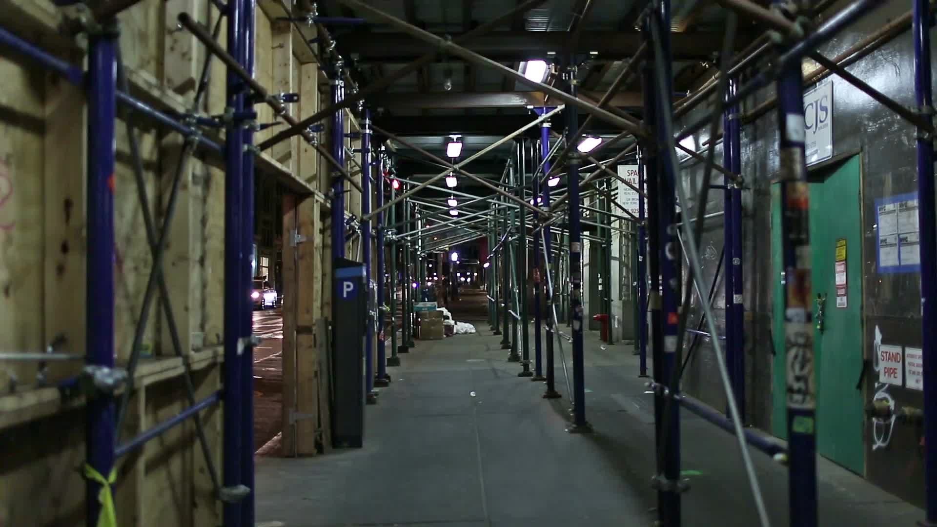 passageway under scaffolding bars on noisy night with ambient noise of street in NYC