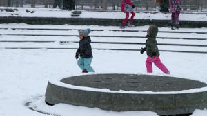 children running happy in snow storm, winter blizzard - kids playing in Washington Square Park slow motion 4K