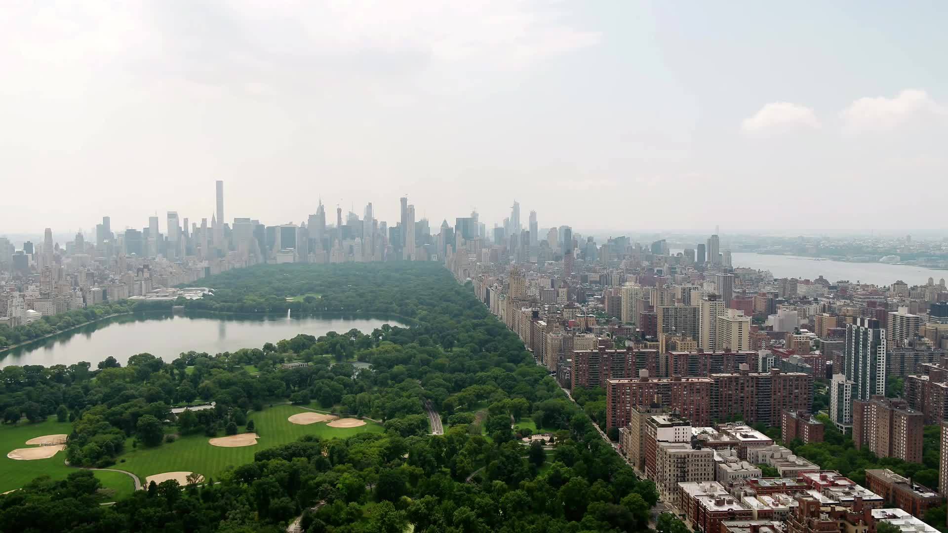 Central Park aerial moving forward toward buildings over green Manhattan New York City NYC