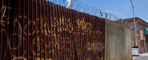 rusty fence gate with gritty graffiti in Brooklyn
