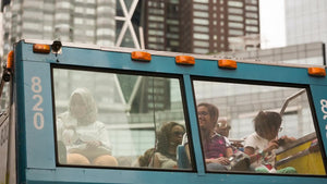 happy tourists on City Sights tour bus at Columbus Circle on summer day in NYC