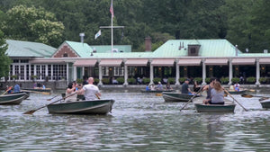 people rowing in row boats on Central Park lake, pond water in summer
