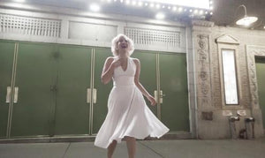 Marilyn Monroe look alike laughing in front of green Broadway theater doors in New York City NYC