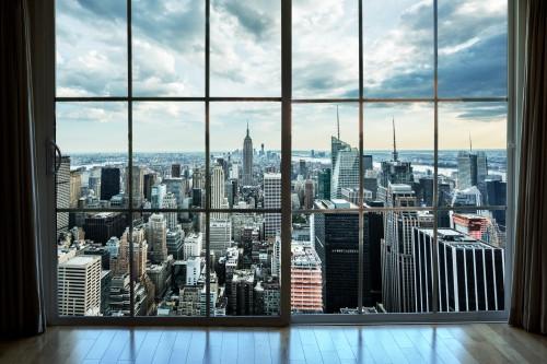Manhattan cityscape view from high-rise window with curtains in luxury real estate interior apartment - Empire State Building and skyscrapers and buildings in New York City NYC