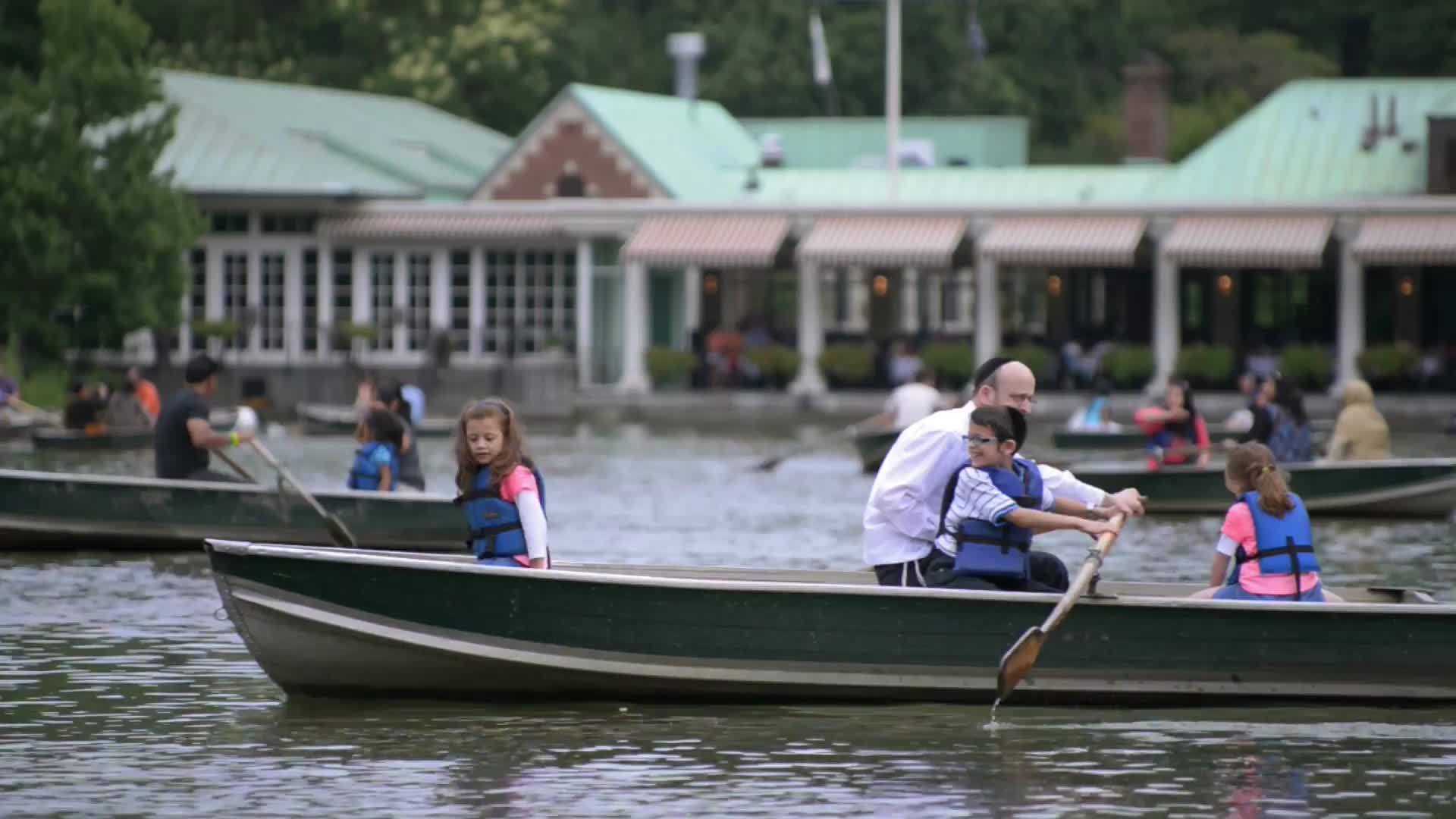 people in row boats in Central Park - Jewish family rowing in lake pond water