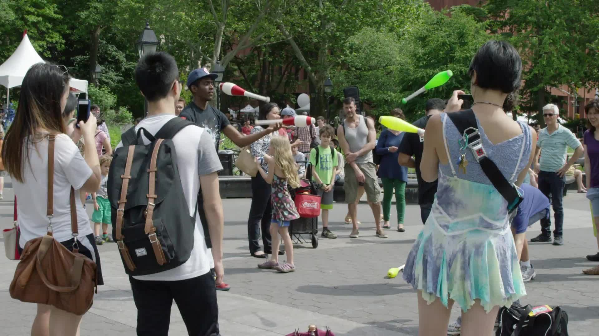 jugglers performing in Washington Square Park in summer - juggling bowling pins in slow motion