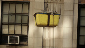 construction bucket rising alongside building in Manhattan NYC