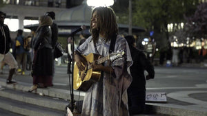 man singing and playing guitar in Union Square Park at night summer