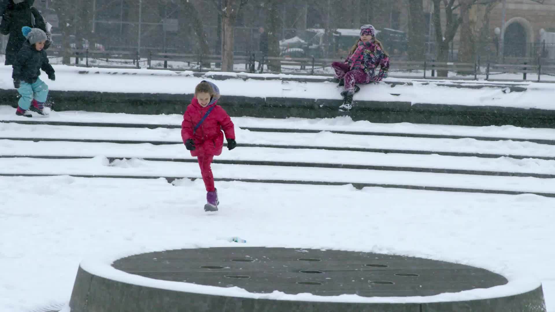 children running in slow motion - snow in Washington Square Park circle during winter blizzard - snowing in New York City NYC 4K and 1080 HD