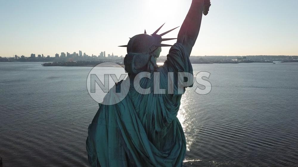 Statue of Liberty back in New York Harbor - aerial over water in NYC