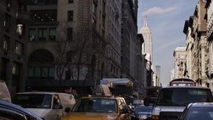 cars stuck in gridlocked traffic on 5th Avenue with Empire State Building in background on Manhattan day
