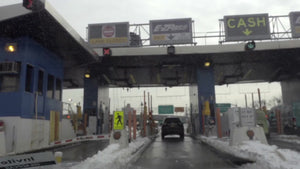car driving pov entering e-z pass toll on highway snow in winter NYC