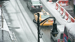 blizzard in Manhattan overhead shot double decker tour bus driving in snow snowing on street winter NYC