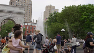 people walking in Washington Square Park by Tisch Fountain in summer in slow motion - famous landmark arch