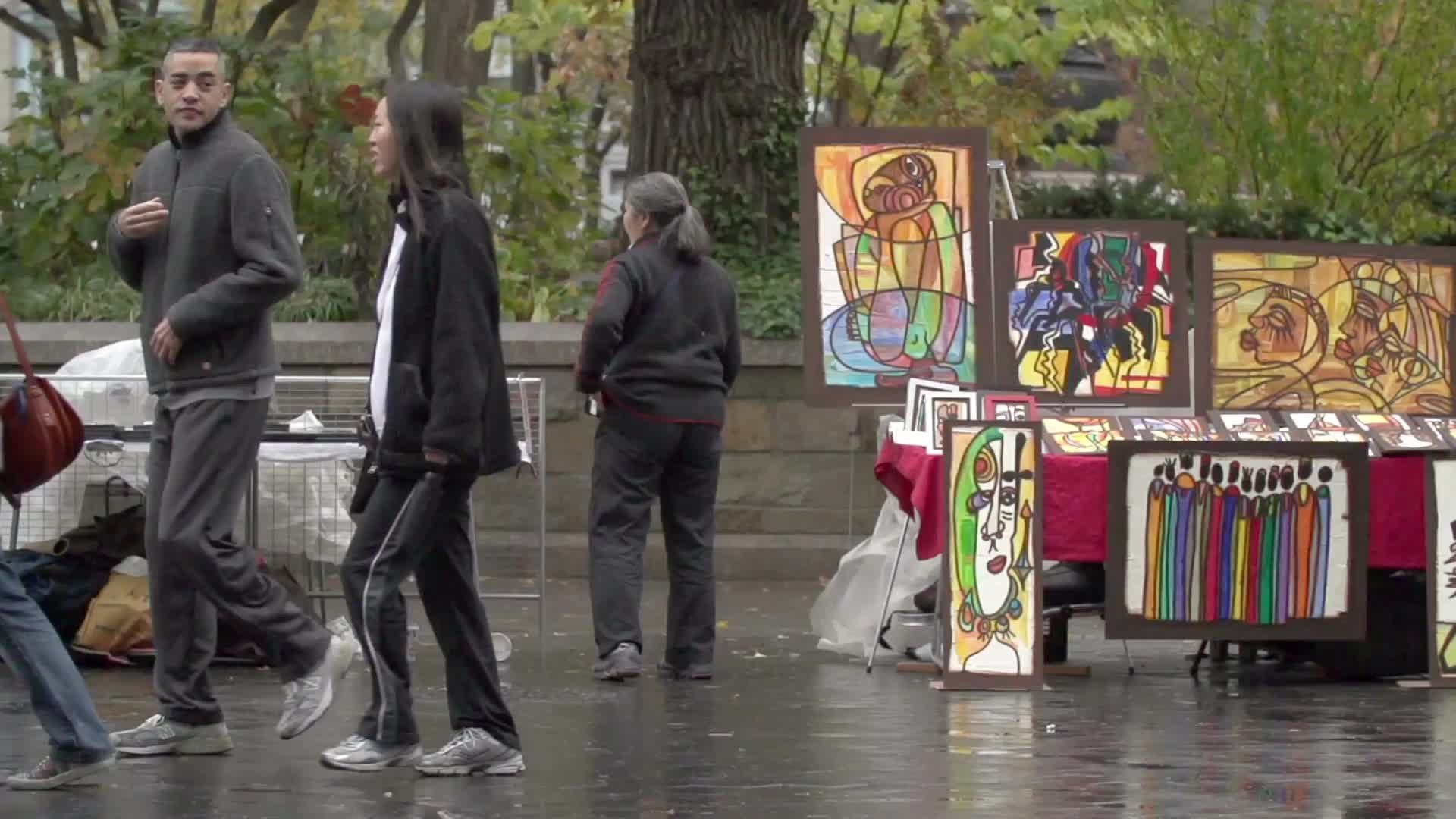 art on display at Union Square Park on street on wet fall day in NYC