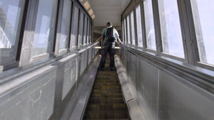 up escalator in 125th street subway station in Harlem - kid with backpack riding escalator going up