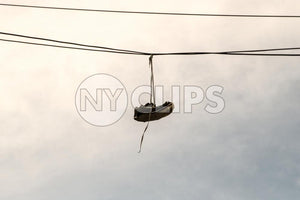 shoes dangling on wire - gritty sneakers hanging on cable - shoefetty