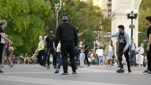 kid flipping and spinning in air breakdancing in Washington Square Park in summer - hip hop dance crew - group dancing