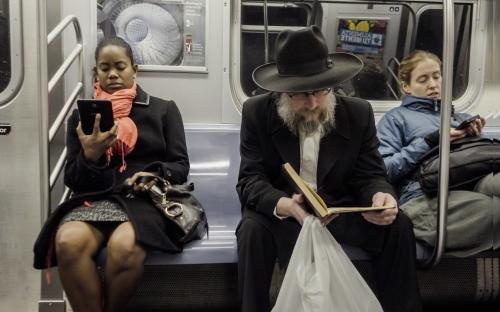 black woman and Jewish man on subway reading - diversity on public transportation in New York City NYC