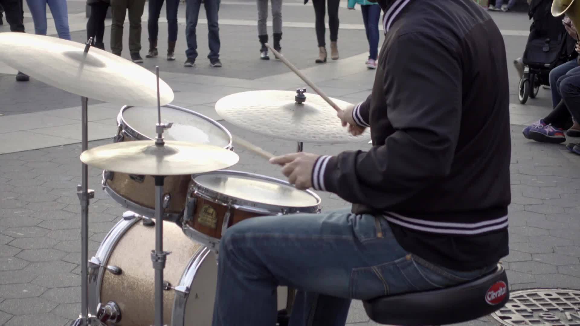 drummer playing music with band musicians - drumming in Washington Square Park on cold fall day - Manhattan New York City NYC
