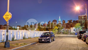 dead end sign in Brooklyn with Empire State Building and skyline in background at night in NYC