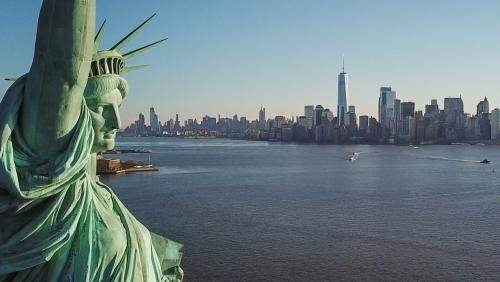 close-up of Statue of Liberty face with Manhattan Island skyline in background in New York City NYC