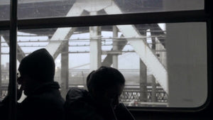 silhouettes of passengers riding B Train crossing Manhattan Bridge - dark interior in NYC