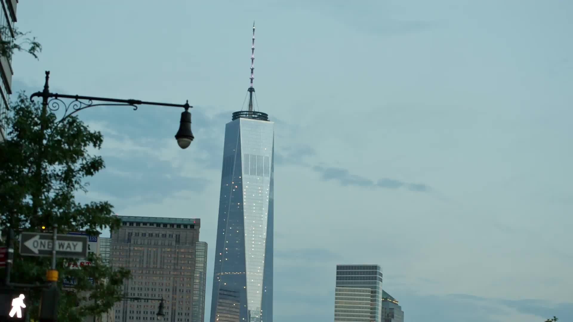 Freedom Tower view from West Side Highway in early evening with cars driving - headlights on road in NYC