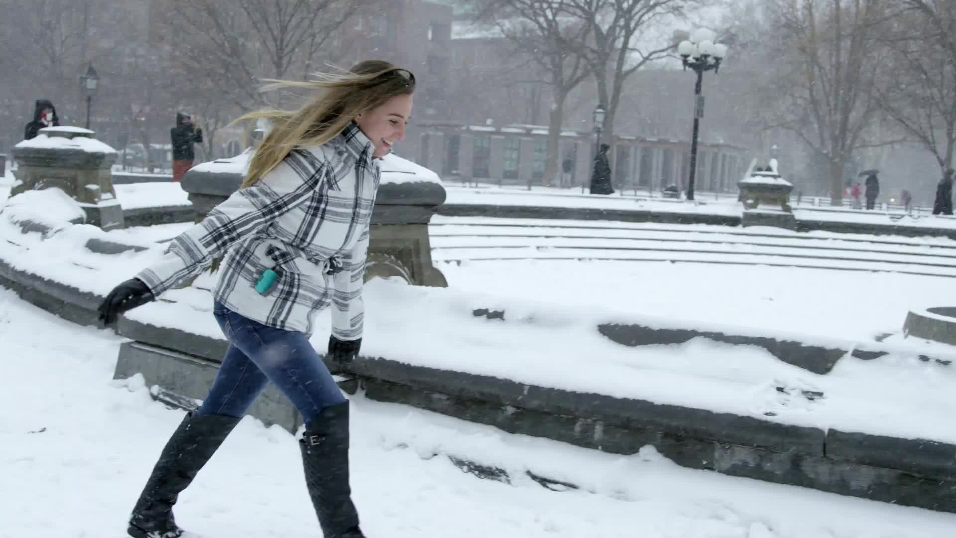 girl running in snow, blizzard in Washington Square Park snowing in winter storm slow motion 4K