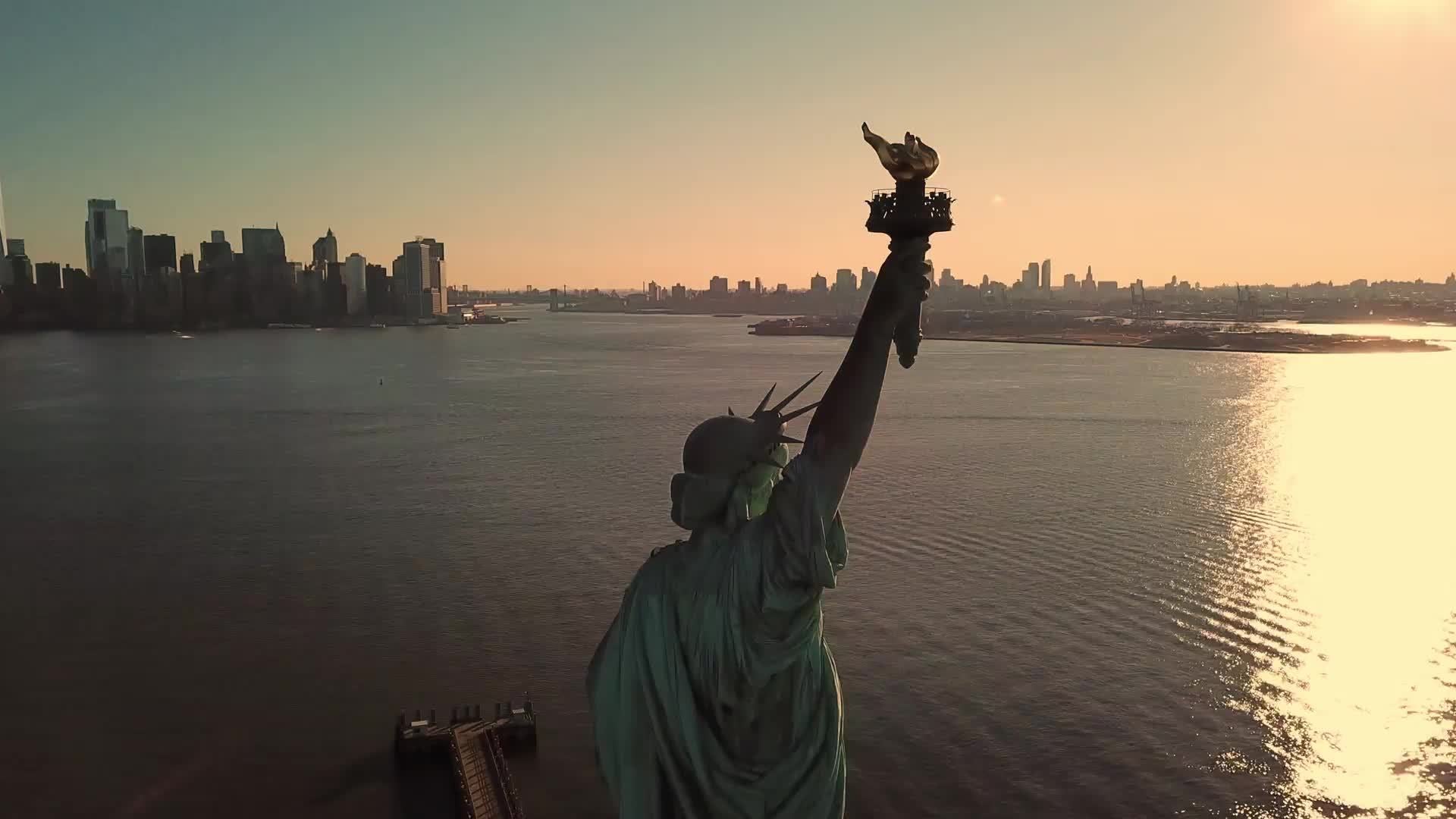 Statue of Liberty during day - aerial circling medium shot with Manhattan New York City skyline in background -n NYC 4K and 1080 HD
