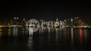 Manhattan skyline at night with reflections off water New York City NYC