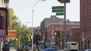 125th Street sign - cars and bus driving in street in Harlem - uptown