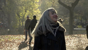 beautiful woman shaking head hair leaves in Central Park in fall autumn happy fun lady