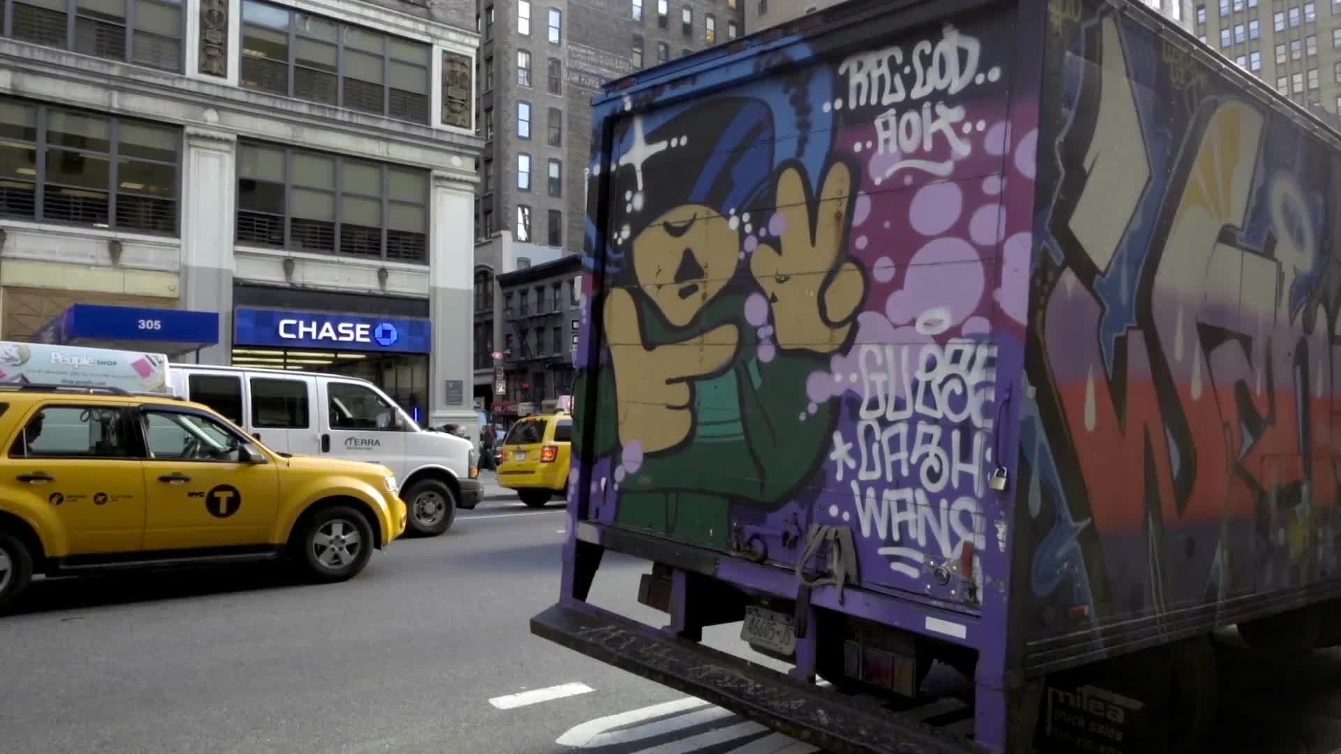 beautiful colorful graffiti truck parked on 7th Ave in Manhattan outside FIT on fall day in slow motion NYC