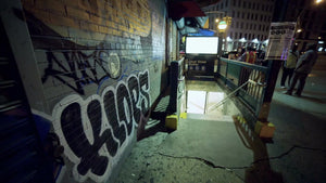 graffiti on wall outside subway station in Lower Manhattan at night