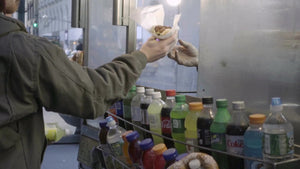 man taking hot dog from window of food cart in New York City NYC