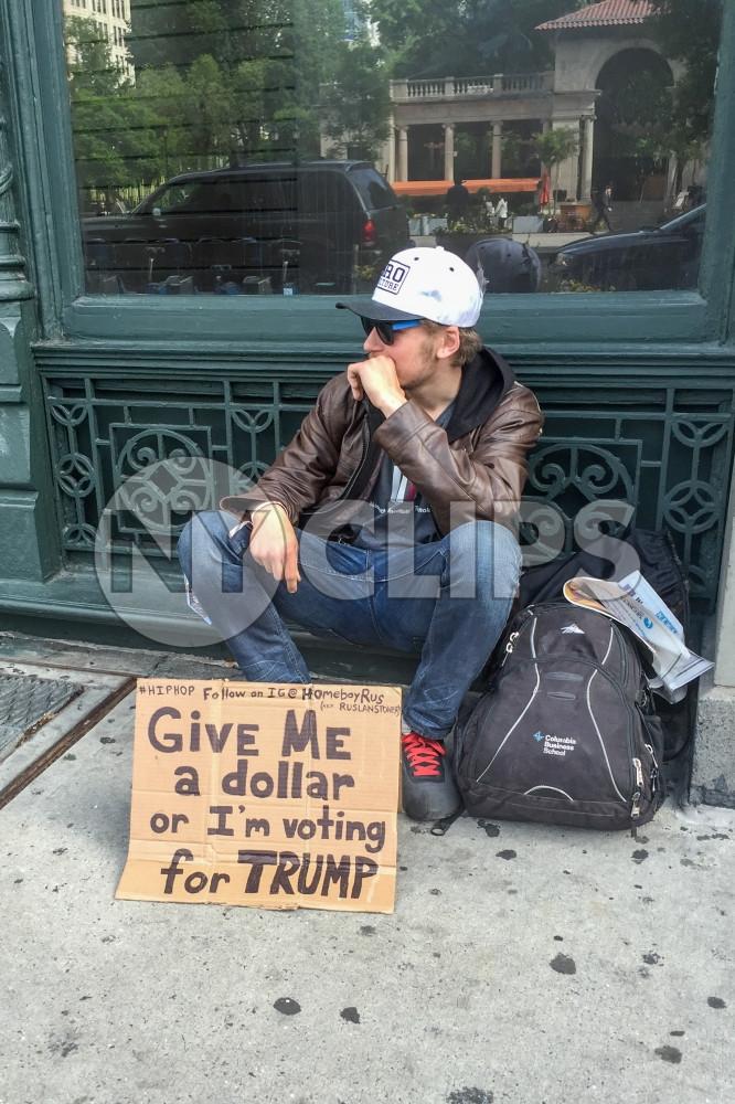 guy on street with homeless sign - Trump hate in NYC