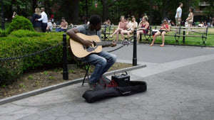 man playing guitar in Washington Square Park in New York City