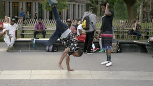 kid breakdancing, spinning in Washington Square Park in NYC
