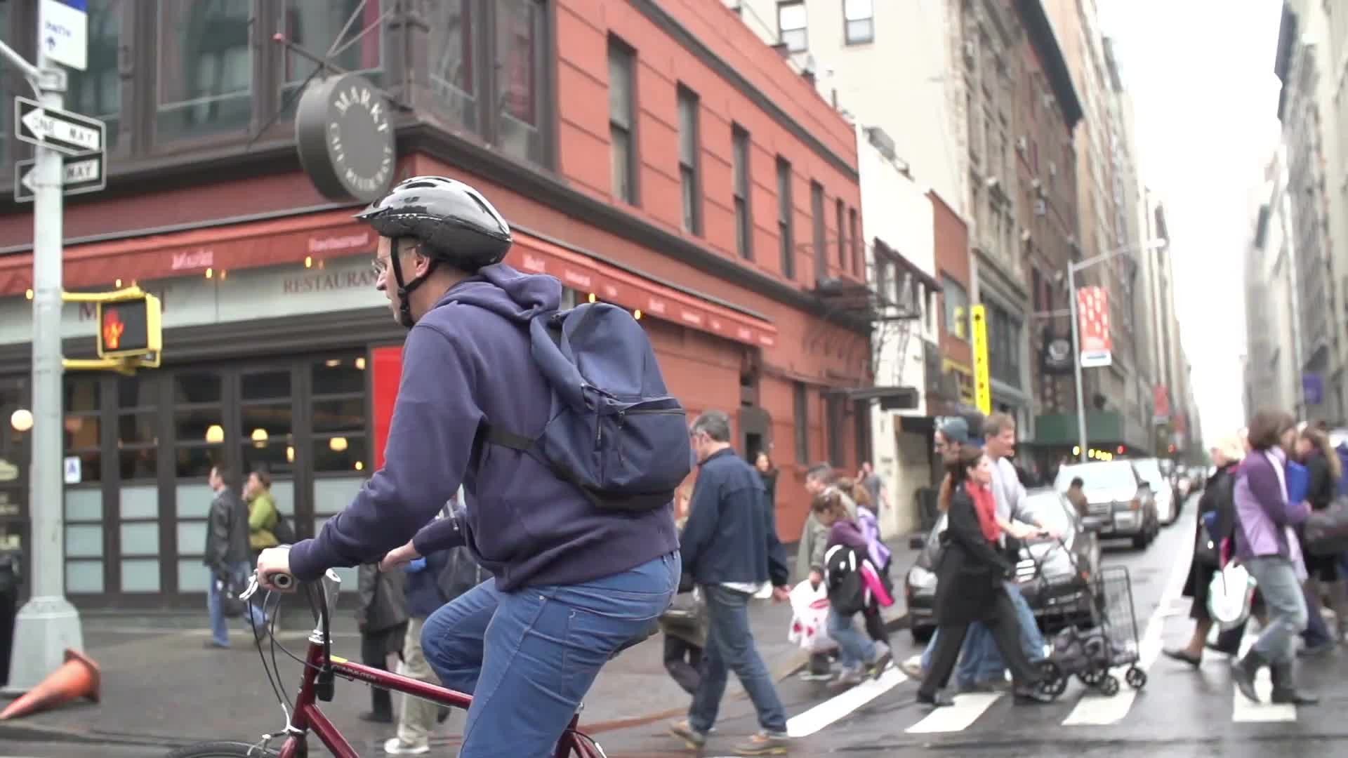 man on bicycle with helmet on fall day - 6th avenue in NYC