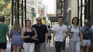 tourists walking down street on summer day in slow motion NYC