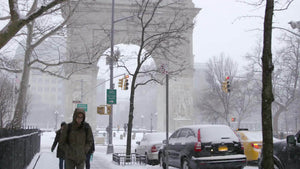 winter blizzard Washington Square Park arch snow storm people coats walking freezing cold NYC