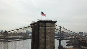 Brooklyn Bridge aerial on American flag circling in New York City NYC 1080 HD